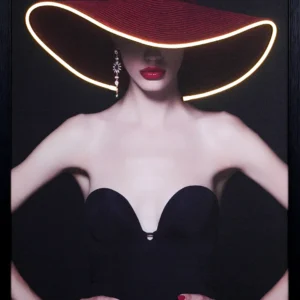 Red Hat Elegance LED wall decor featuring a fashion portrait of a woman in a wide brim crimson hat with warm gold LED outline, red lips, crystal drop earring and black strapless gown on dark background, framed wall decor
